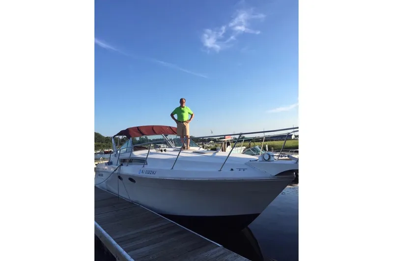 Slide: The Image of 1989 Wellcraft 3200 St. Tropez boat docked with person standing on deck. - 3