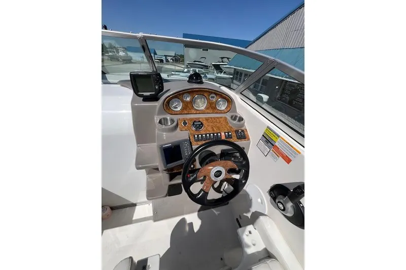 Slide: The Image of 2007 Rinker Fiesta Vee 250 boat dashboard with steering wheel and navigation instruments. - 13