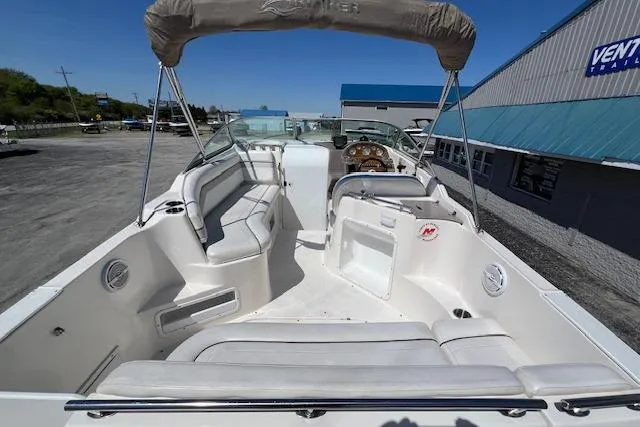 Slide: The Image of 2007 Rinker Fiesta Vee 250 boat interior with seating and helm, parked outdoors. - 19