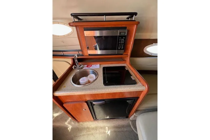 Slide: The Image of 2007 Rinker Fiesta Vee 250 boat kitchenette with microwave, sink, and mini-fridge. - 6