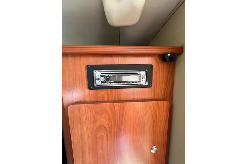Slide: The Image of 2007 Rinker Fiesta Vee 250 cabin with wood paneling and built-in stereo system. - 7