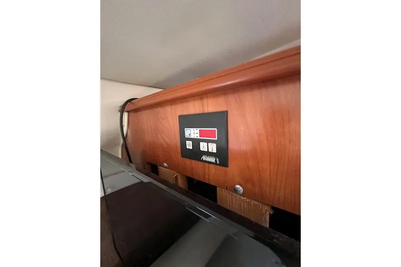 Slide: The Image of Control panel inside 2007 Rinker Fiesta Vee 250 boat, mounted on wooden surface. - 9