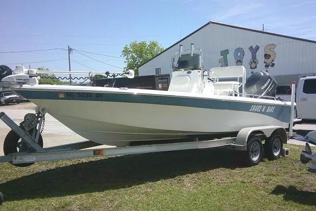 The Image of 2008 NauticStar 2110 Nautic Bay boat on trailer, parked outdoors near a toy store. - 0