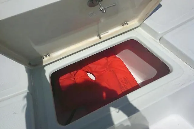 Slide: The Image of Open storage compartment on 2008 NauticStar 2110 Nautic Bay boat with red life jacket. - 14