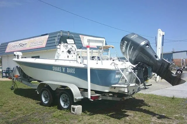 Slide: The Image of 2008 NauticStar 2110 Nautic Bay boat on trailer, parked outdoors near a building. - 2