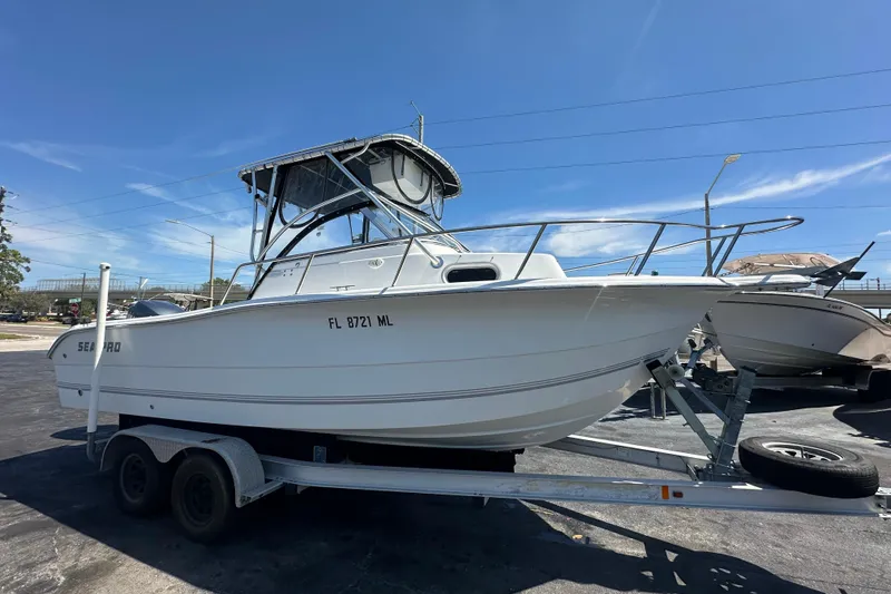 The Image of 2004 Sea Pro 220 Walk Around boat on trailer under clear blue sky. - 0