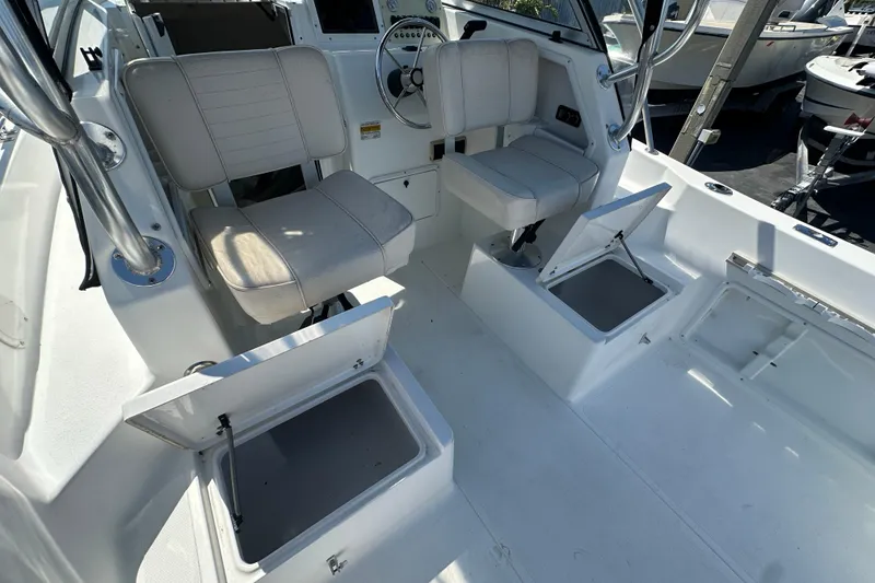 Slide: The Image of 2004 Sea Pro 220 Walk Around boat interior with seating and storage compartments. - 12