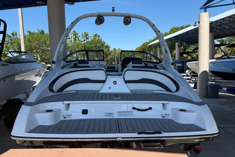 Slide: The Image of 2023 Yamaha Boats 195S, sleek design, rear view, displayed outdoors under canopy. - 11