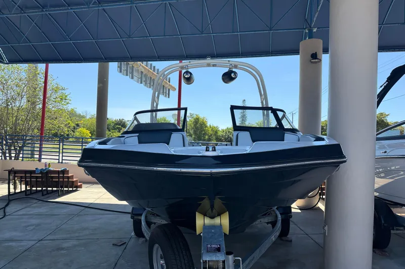 Slide: The Image of 2023 Yamaha Boats 195S displayed on a trailer under a canopy. - 2