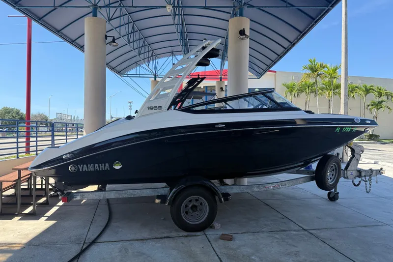 Slide: The Image of 2023 Yamaha Boats 195S on trailer under canopy, ready for transport. - 5