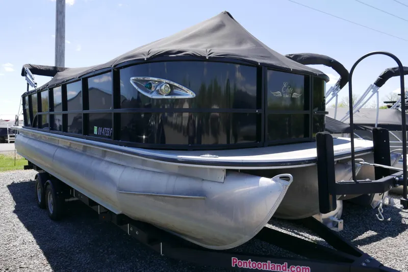 Slide: The Image of 2019 Bentley 253 Admiral RE pontoon boat on trailer, black canopy, parked outdoors. - 12