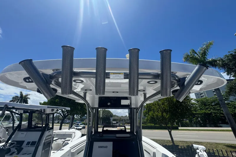 Slide: The Image of 2026 Sea Pro 262 DLX boat with fishing rod holders under blue sky. - 21