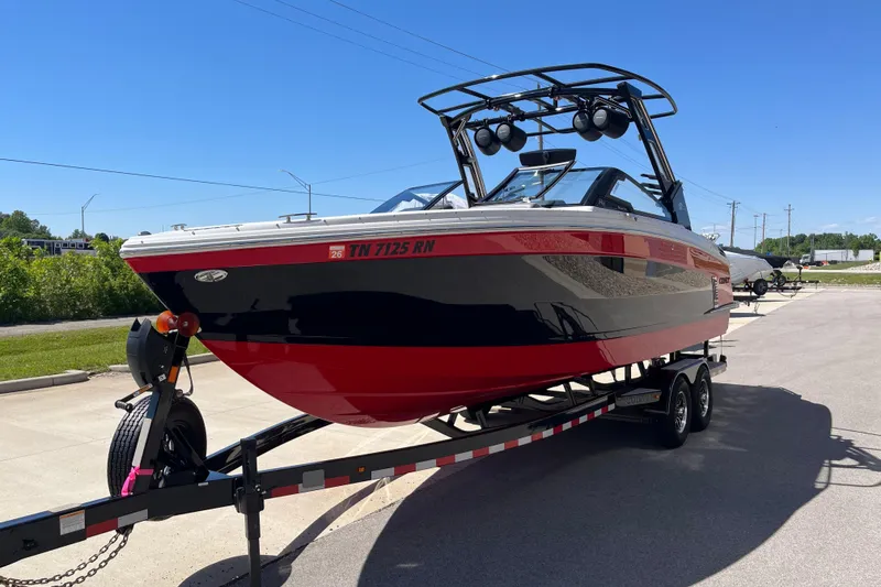 Slide: The Image of 2023 Cobalt R8 Surf boat on trailer, red and black design, parked outdoors. - 4