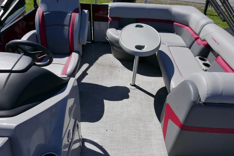 Slide: The Image of 2023 Trifecta C Series boat interior with gray and red seating, round table, and steering console. - 9