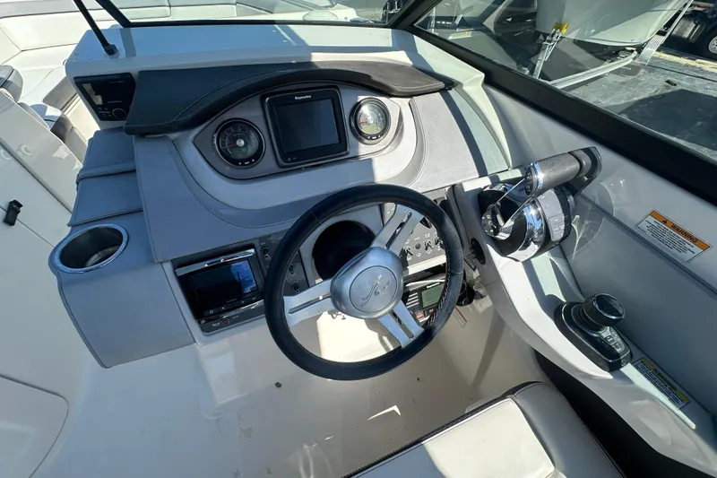 Slide: The Image of 2017 Sea Ray SDX 290 Outboard helm with steering wheel and control panel. - 17