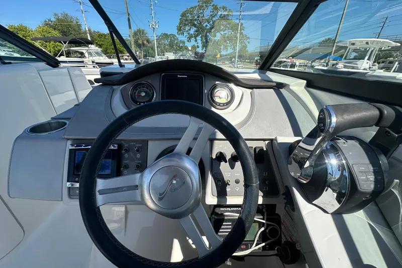 Slide: The Image of Cockpit view of 2017 Sea Ray SDX 290 Outboard, featuring steering wheel and controls. - 18
