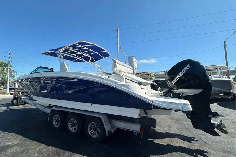 Slide: The Image of 2017 Sea Ray SDX 290 Outboard boat with Mercury engine on trailer, under clear blue sky. - 2