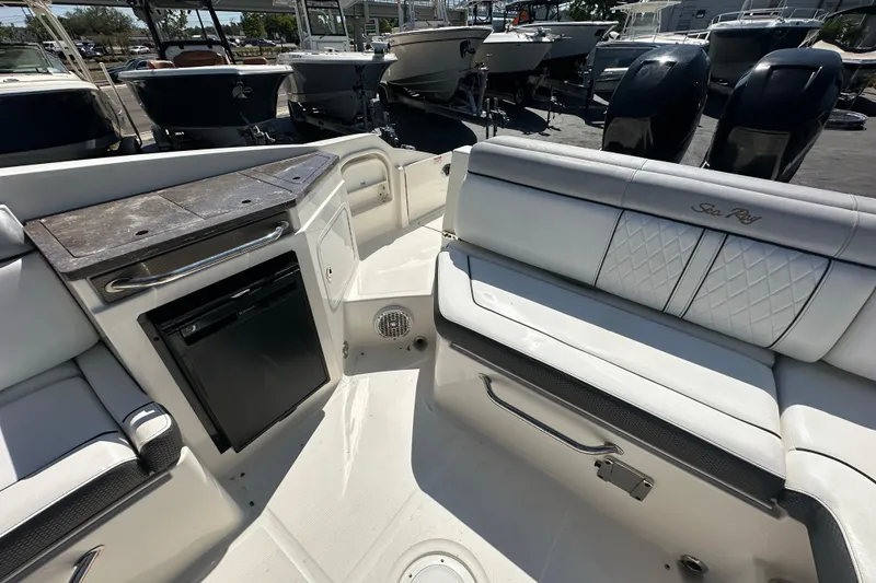 Slide: The Image of 2017 Sea Ray SDX 290 Outboard interior with seating and storage, docked among other boats. - 22