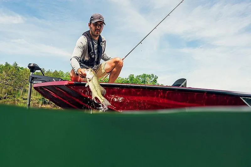 Slide: The Image of Manufacturer Provided Image: Man fishing on 2025 Lowe Stinger 175C boat, catching fish in scenic lake. - 2