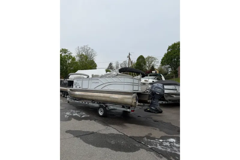 The Image of 2023 Sylvan Mirage 820 LZ pontoon boat on trailer, parked outdoors. - 0