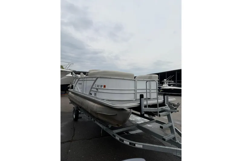 Slide: The Image of 2023 Sylvan Mirage 820 LZ pontoon boat on trailer, overcast sky background. - 2
