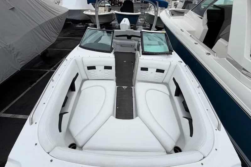 Slide: The Image of Interior view of 2023 Four Winns HD5 OB boat, featuring white seating and storage compartment. - 12