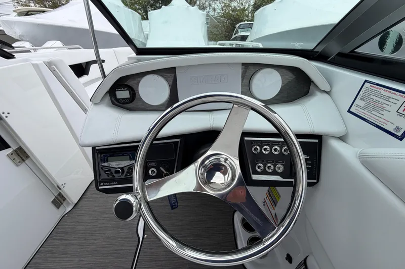 Slide: The Image of 2023 Four Winns HD5 OB boat dashboard with steering wheel and control panel. - 17
