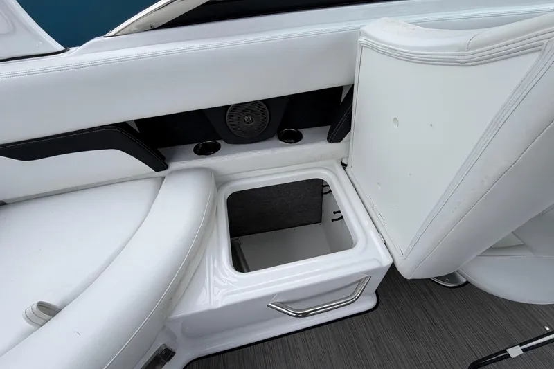 Slide: The Image of 2023 Four Winns HD5 OB boat interior with white seating and storage compartment. - 28