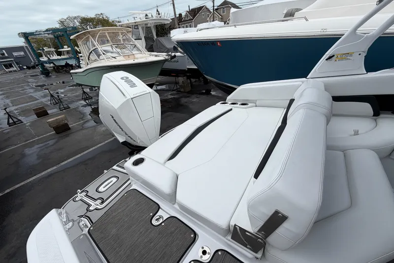 Slide: The Image of 2023 Four Winns HD5 OB boat interior with white seating and Mercury outboard engine. - 35