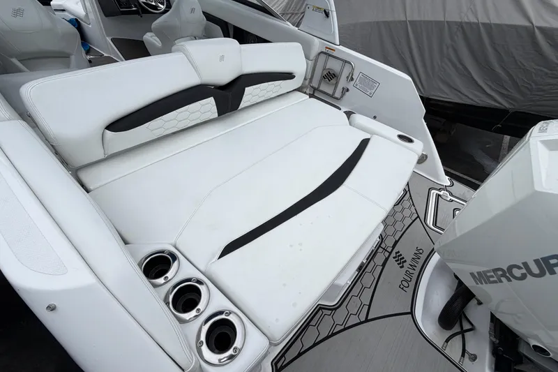 Slide: The Image of 2023 Four Winns HD5 OB boat storage compartment with open lid and cup holders. - 37