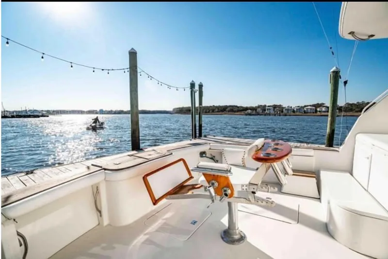 Slide: The Image of 1999 Ocean Yachts 56 Super Sport yacht docked, with scenic waterfront view. - 2