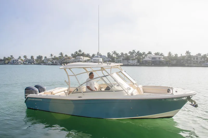 Slide: The Image of 2020 Grady-White Freedom 285 boat cruising on a sunny day near waterfront homes. - 2