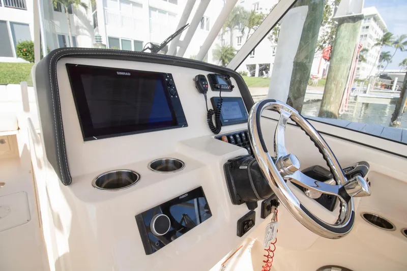 Slide: The Image of 2020 Grady-White Freedom 285 boat helm with steering wheel and navigation controls. - 20