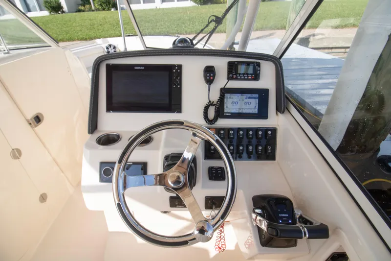 Slide: The Image of 2020 Grady-White Freedom 285 boat helm with steering wheel and navigation controls. - 21