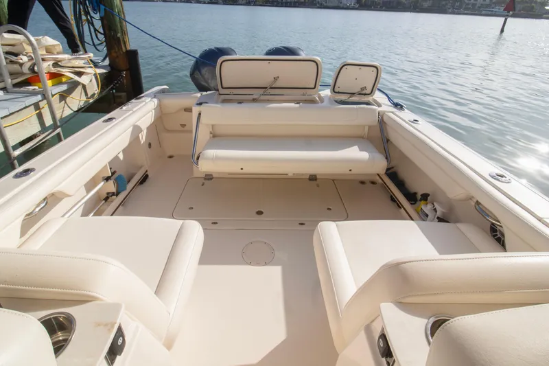 Slide: The Image of 2020 Grady-White Freedom 285 boat interior with spacious seating and storage, docked by the water. - 25