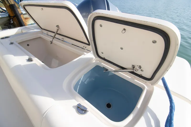 Slide: The Image of Open storage compartments on a 2020 Grady-White Freedom 285 boat by the water. - 27