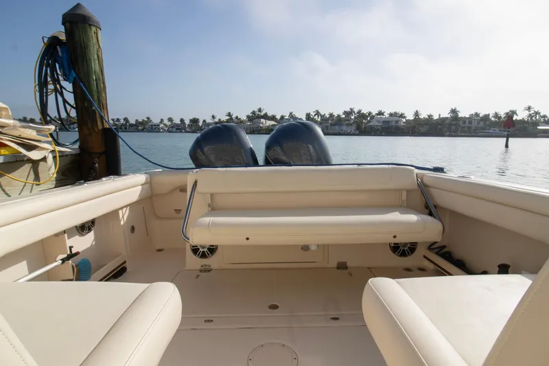 Slide: The Image of 2020 Grady-White Freedom 285 boat interior with dual engines, docked by waterfront homes. - 28