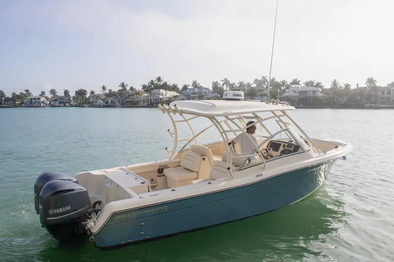 Slide: The Image of 2020 Grady-White Freedom 285 boat cruising on calm waters near a coastal neighborhood. - 3