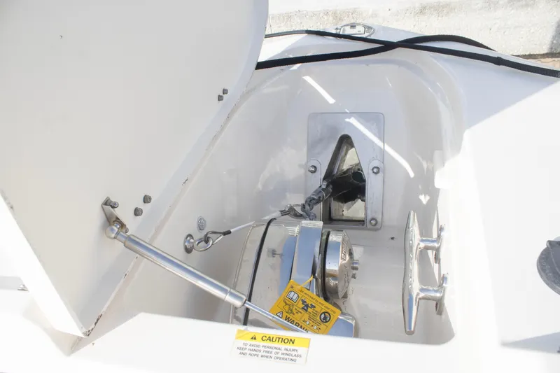 Slide: The Image of Anchor compartment of 2020 Grady-White Freedom 285 boat, featuring winch and caution label. - 8