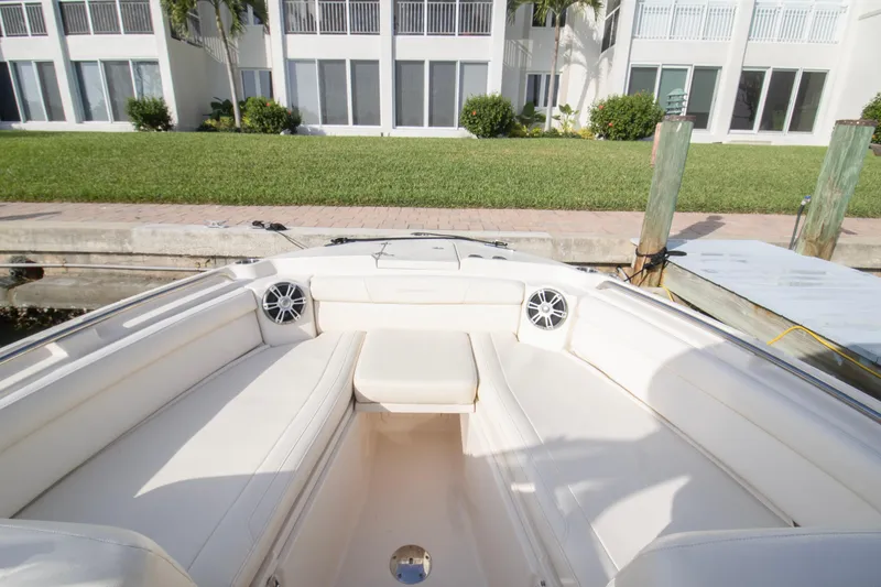 Slide: The Image of 2020 Grady-White Freedom 285 boat interior with white seating, docked near modern building. - 9