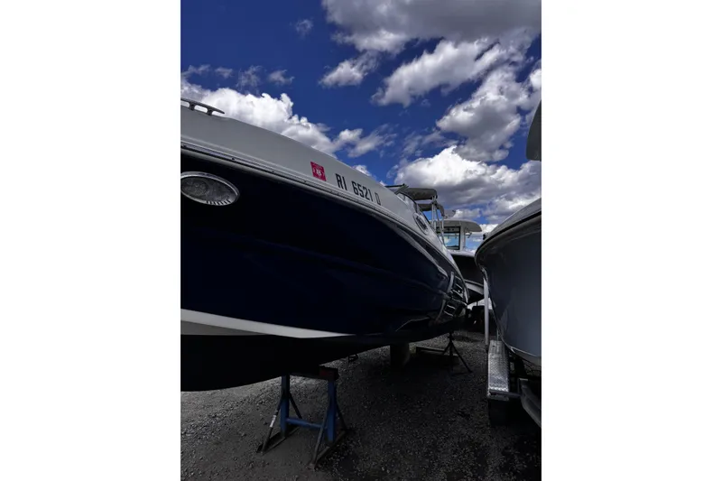 Slide: The Image of 2015 Stingray 234 LR boat on stands under a cloudy blue sky. - 10