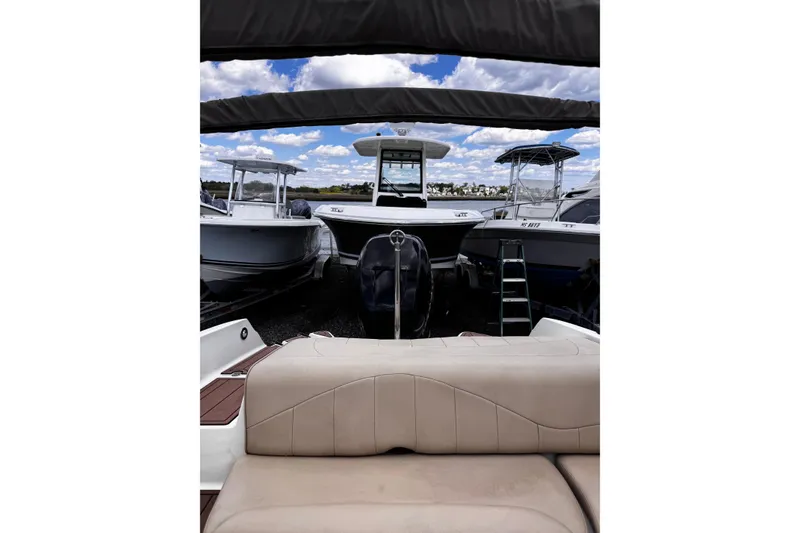 Slide: The Image of 2015 Stingray 234 LR boat interior with surrounding boats under a cloudy sky. - 12