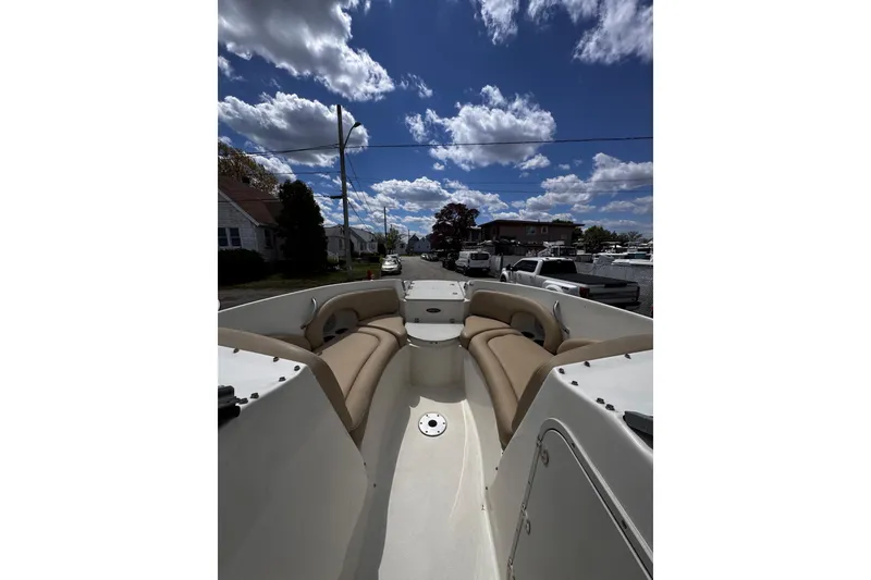Slide: The Image of 2015 Stingray 234 LR boat interior with tan seating under a partly cloudy sky. - 24