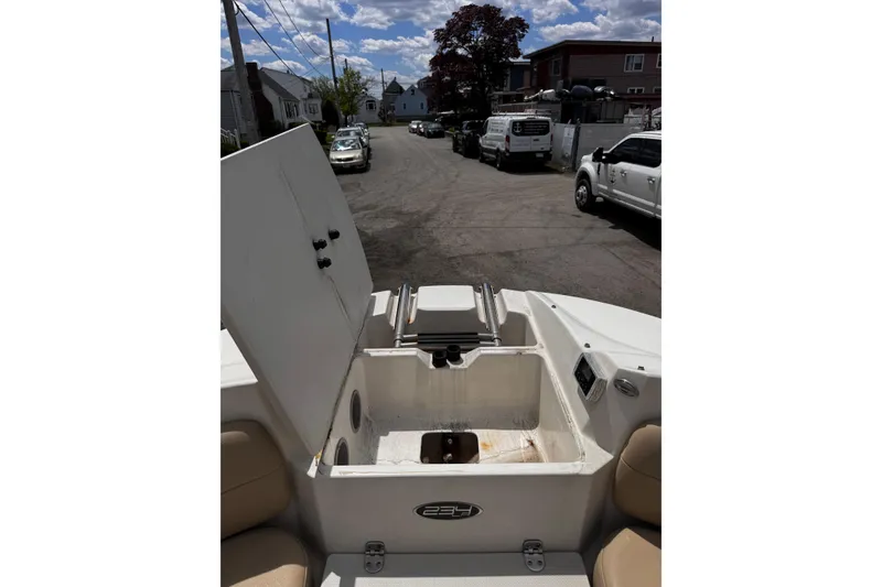 Slide: The Image of 2015 Stingray 234 LR boat interior with open storage compartment on a street. - 26
