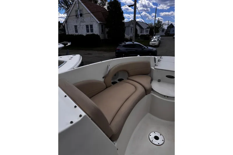 Slide: The Image of 2015 Stingray 234 LR boat interior with beige seating, parked in a residential area. - 27