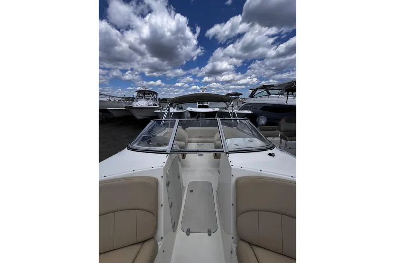 Slide: The Image of 2015 Stingray 234 LR boat with beige seating under a cloudy sky. - 29