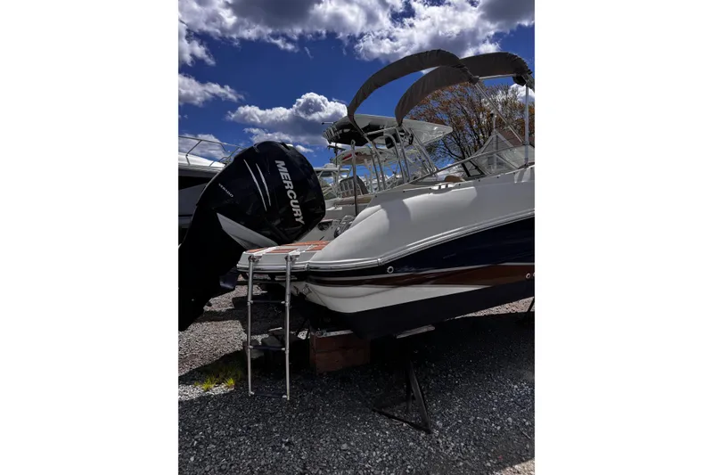 Slide: The Image of 2015 Stingray 234 LR boat with Mercury outboard motor under a cloudy sky. - 4