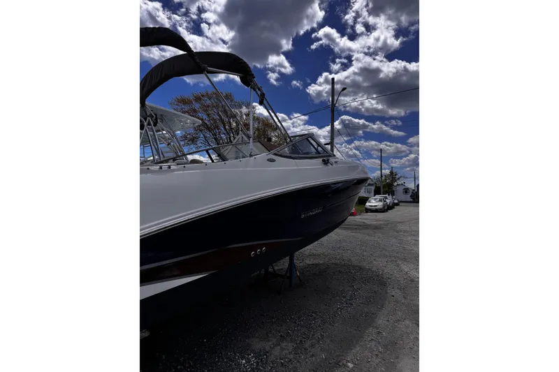 Slide: The Image of 2015 Stingray 234 LR boat parked on gravel under a cloudy sky. - 5