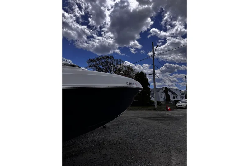 Slide: The Image of 2015 Stingray 234 LR boat on gravel, under cloudy sky, near residential area. - 7