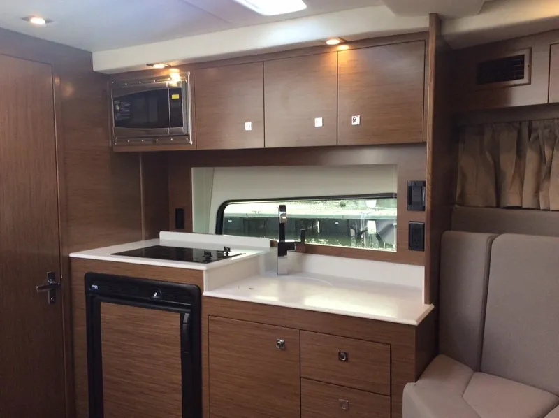 Slide: The Image of Interior of 2020 Cruisers Yachts 390 Express Coupe, modern kitchen with wood finish. - 24